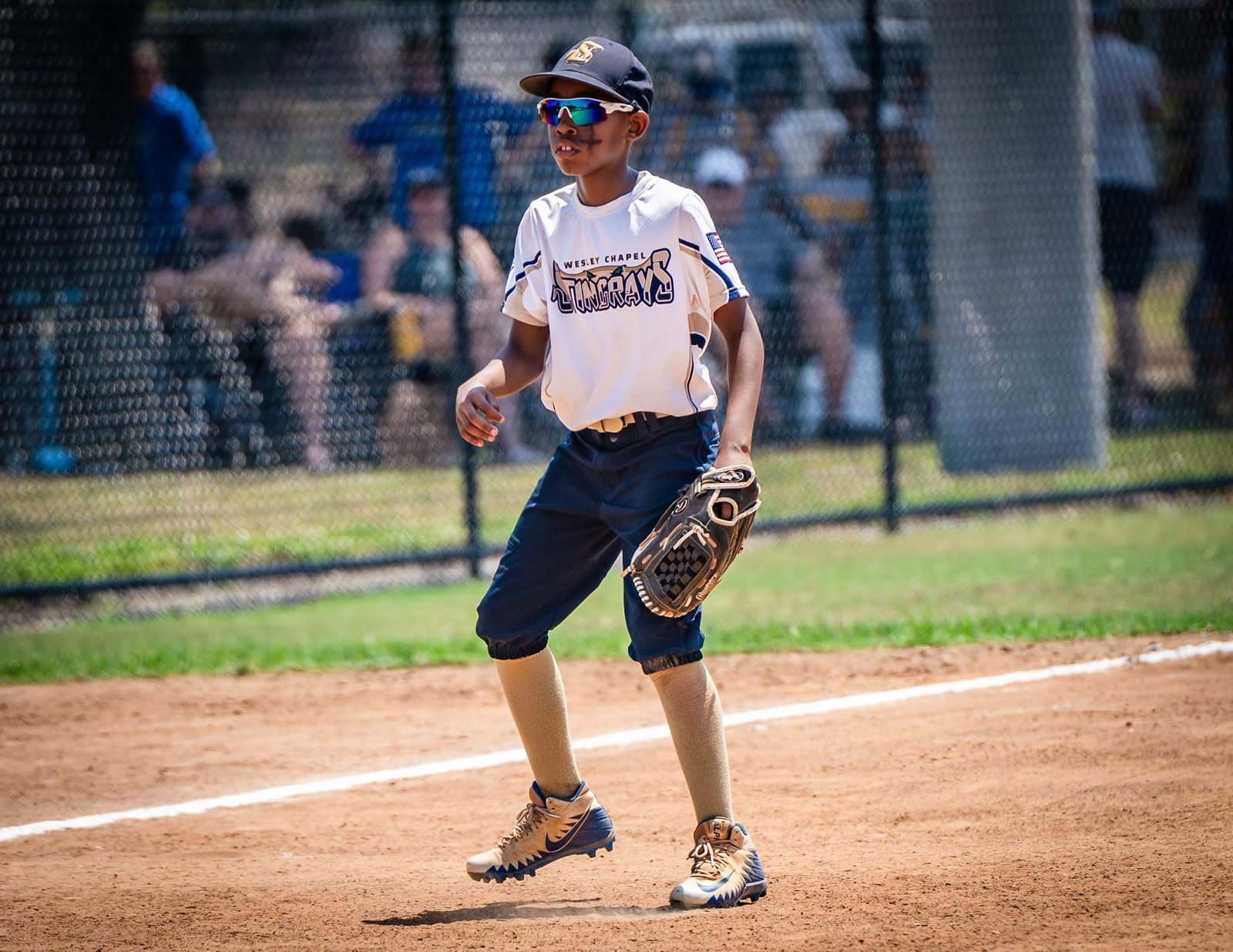 Young baseball player in uniform on field with glove