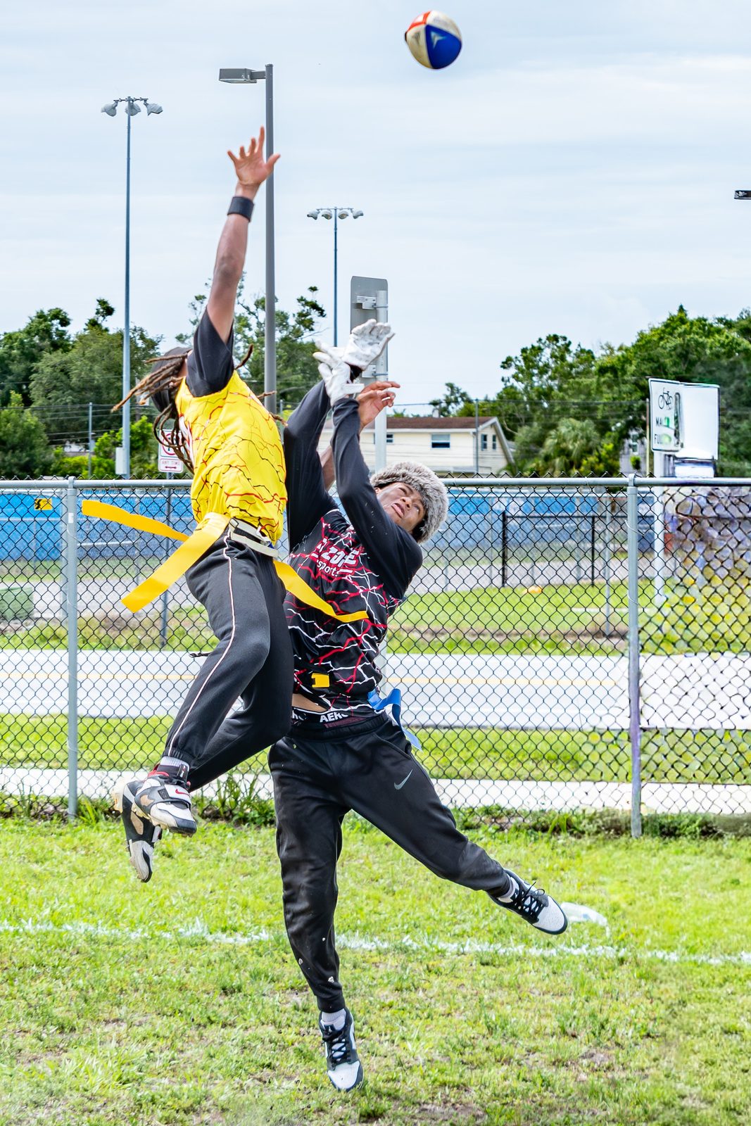 Two athletes jumping to catch a flying disc in a sports game