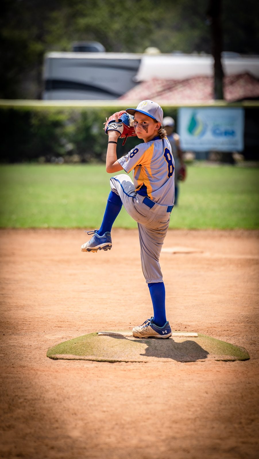 Young baseball pitcher mid-throw on the mound
