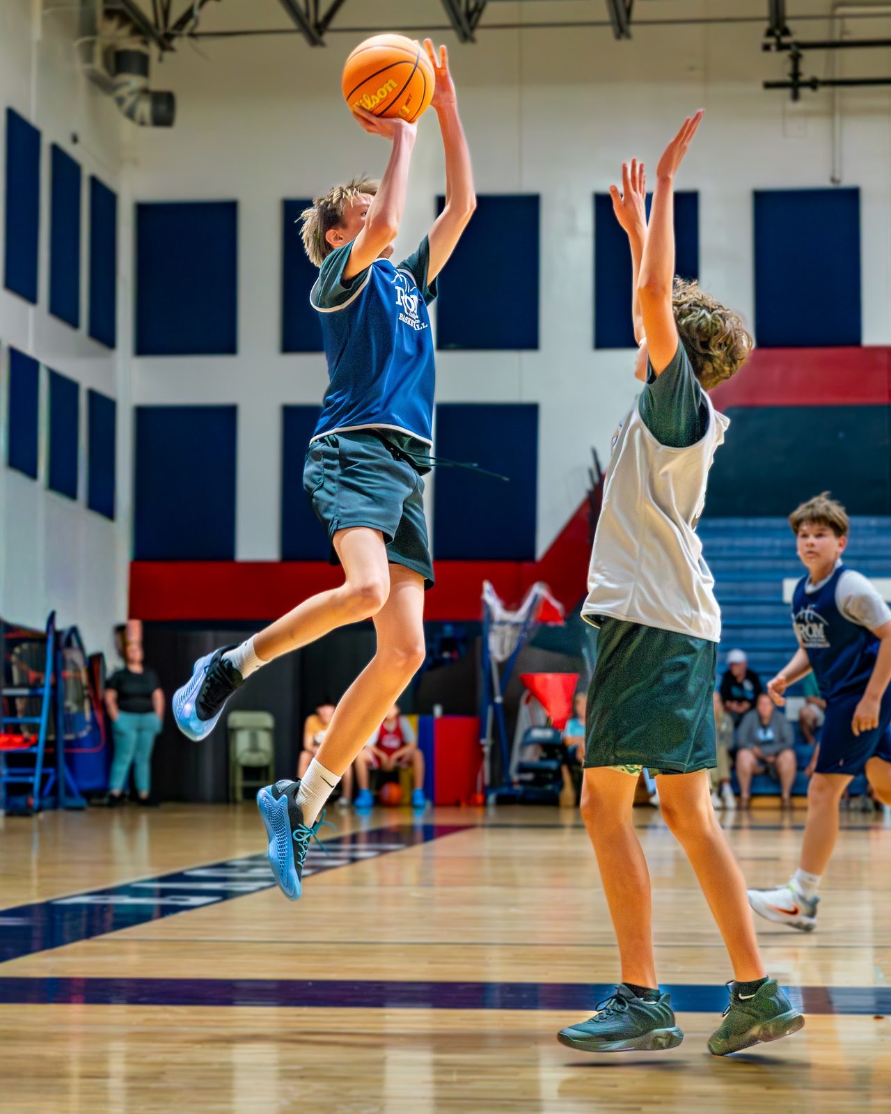 Kids playing basketball in indoor gymnasium during game