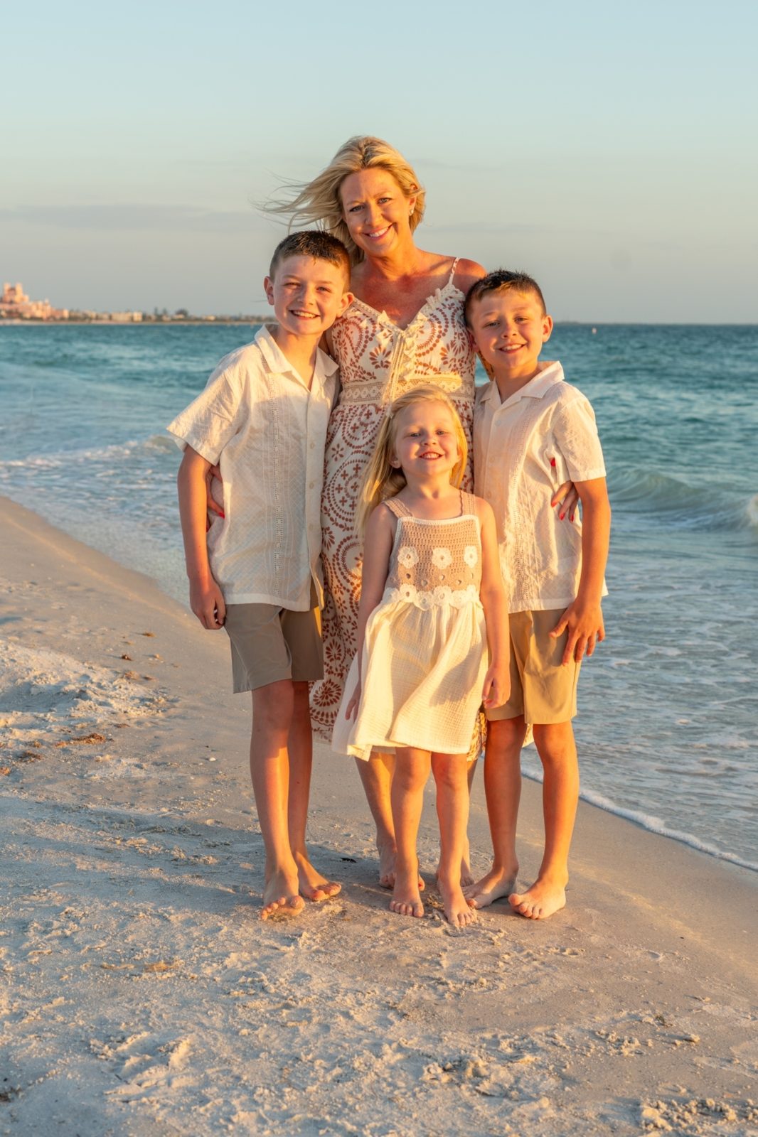 Family group posing on a beach at sunset