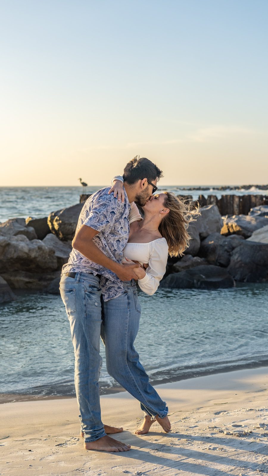 Couple kissing on beach at sunset