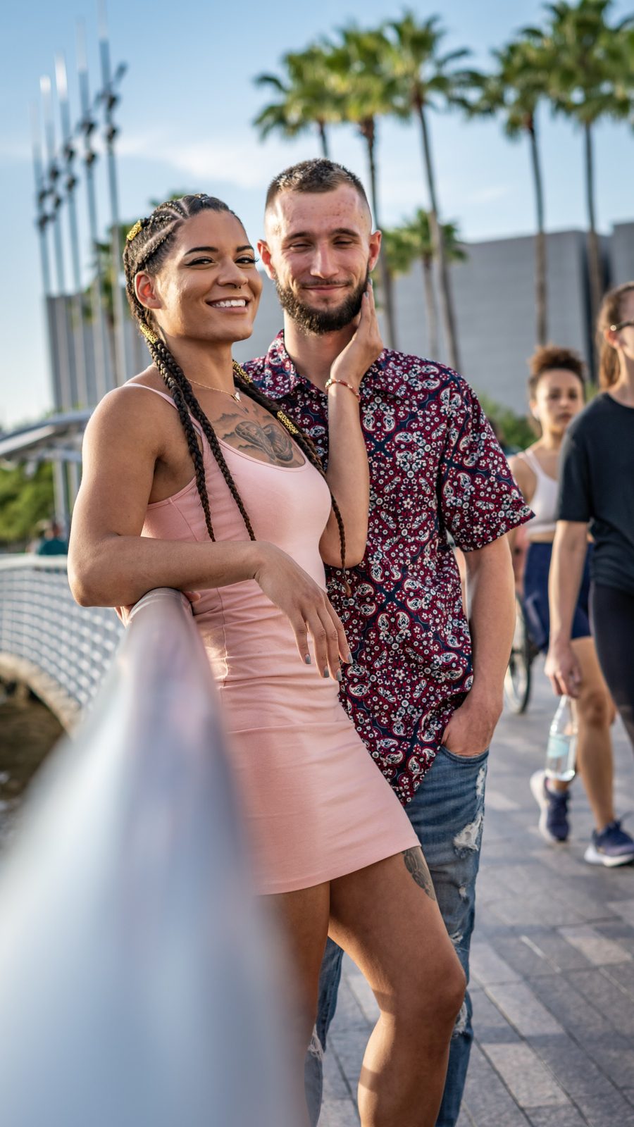 Couple walking on bridge with palm trees