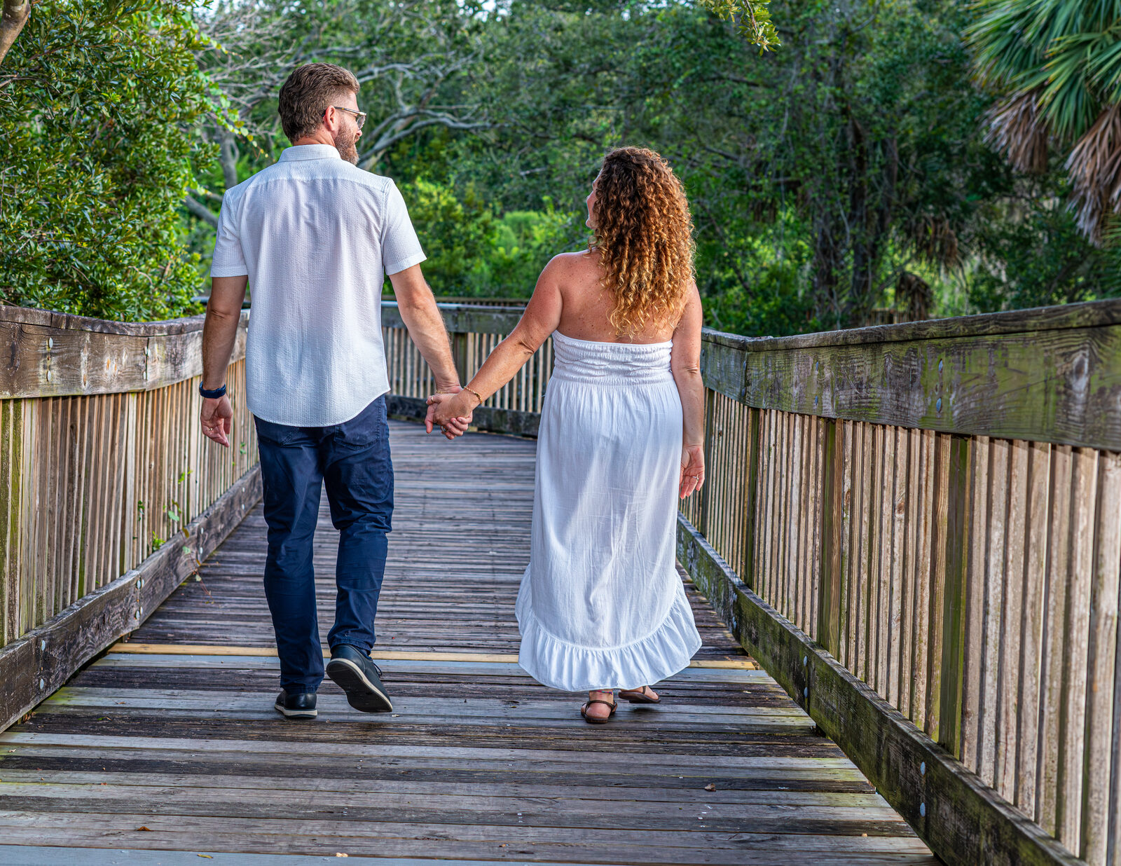 man and woman walking on boardwalk
