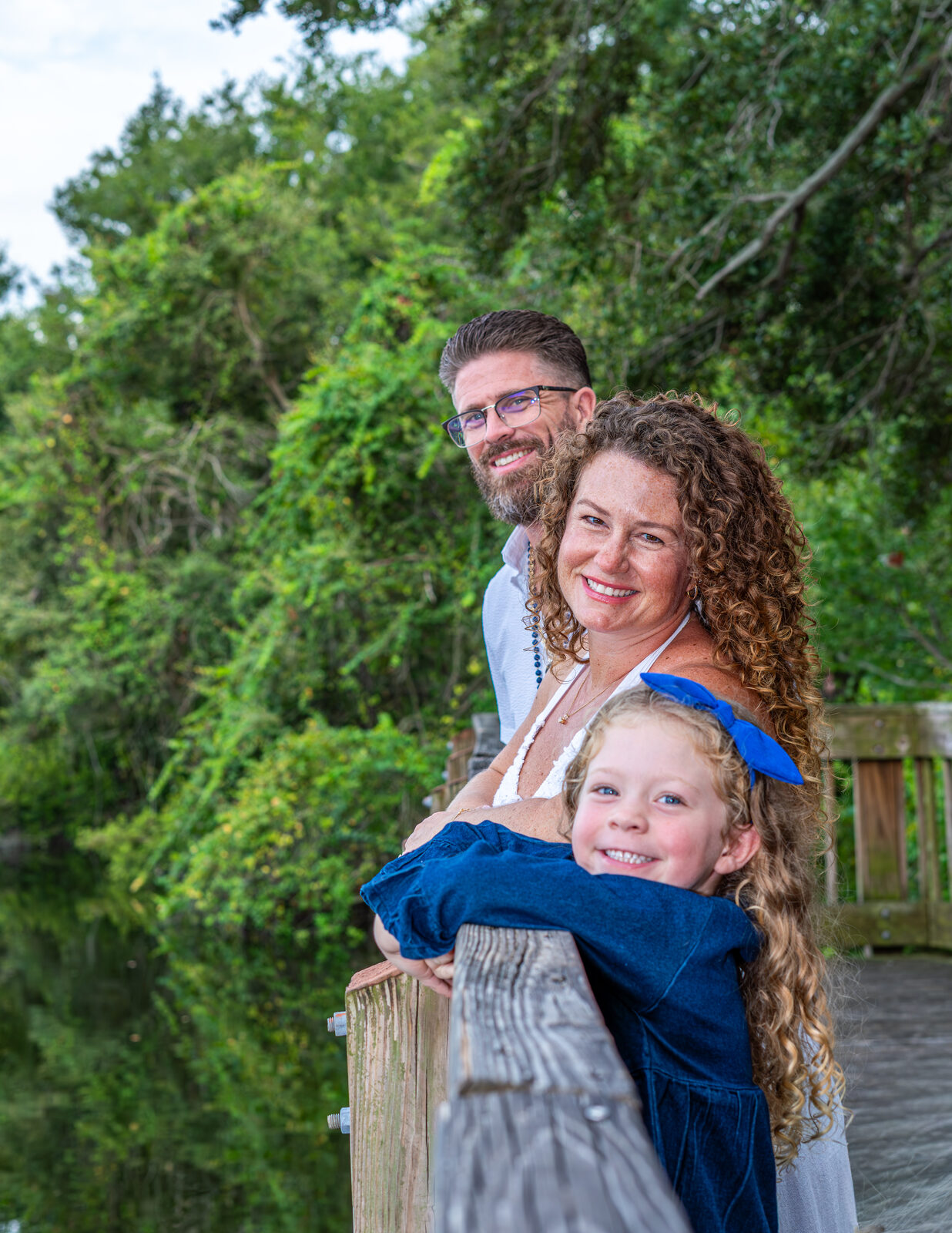 mom dad and child on boardwalk