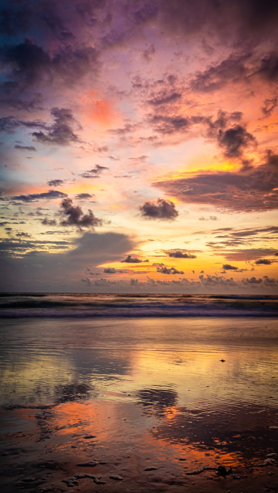 Sunset over ocean with colorful sky and reflective water