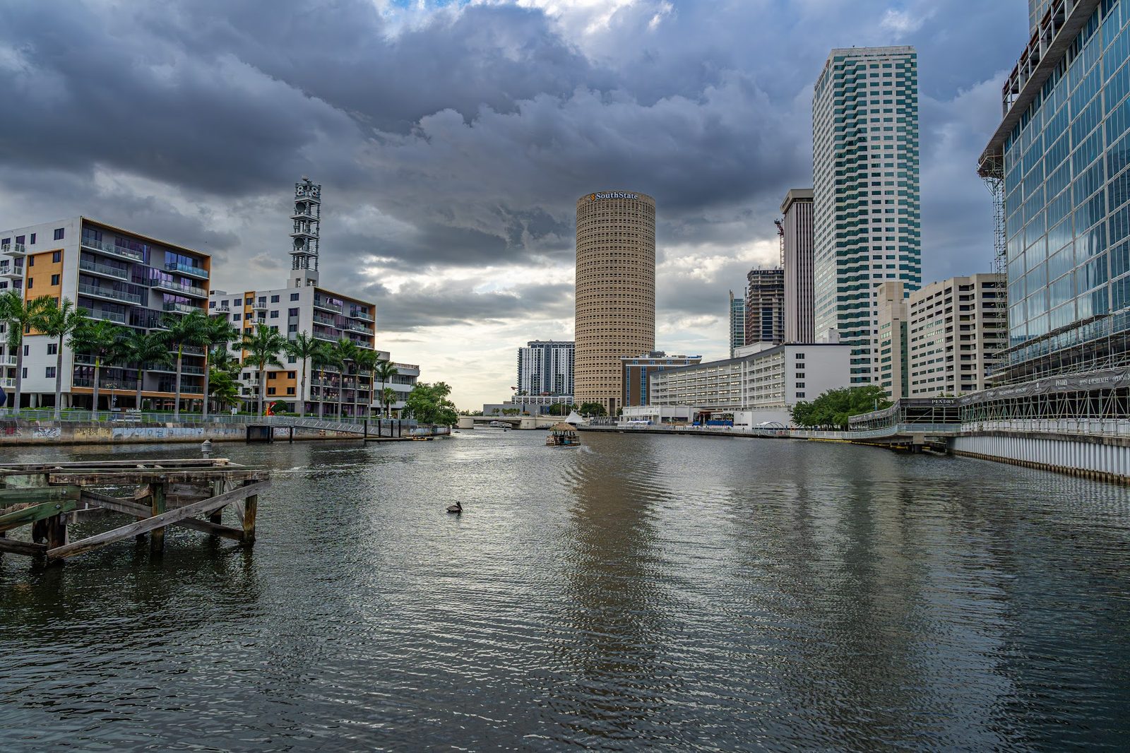 City skyline with river and buildings under cloudy sky