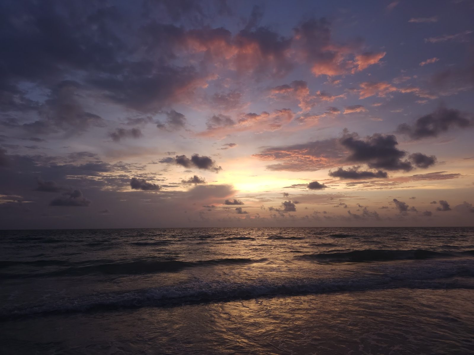 Sunset over ocean with clouds at dusk