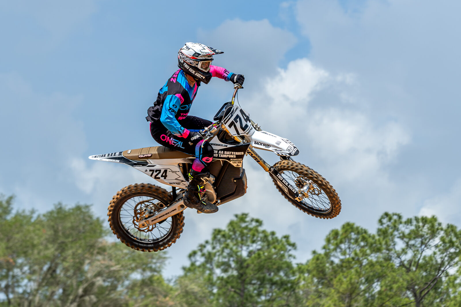 Motocross rider airborne on number 724 dirt bike