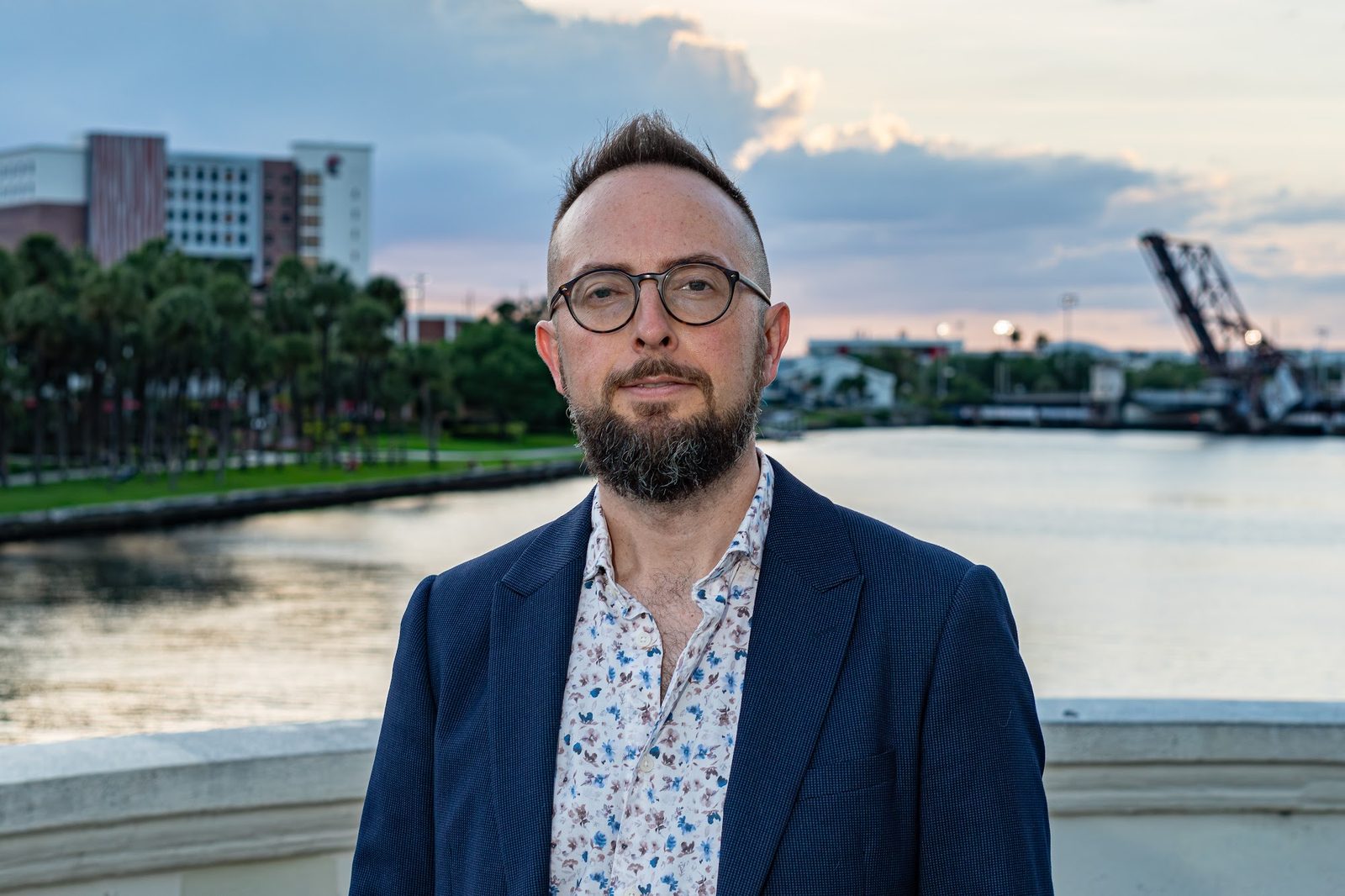 Man in blue blazer and floral shirt at waterfront