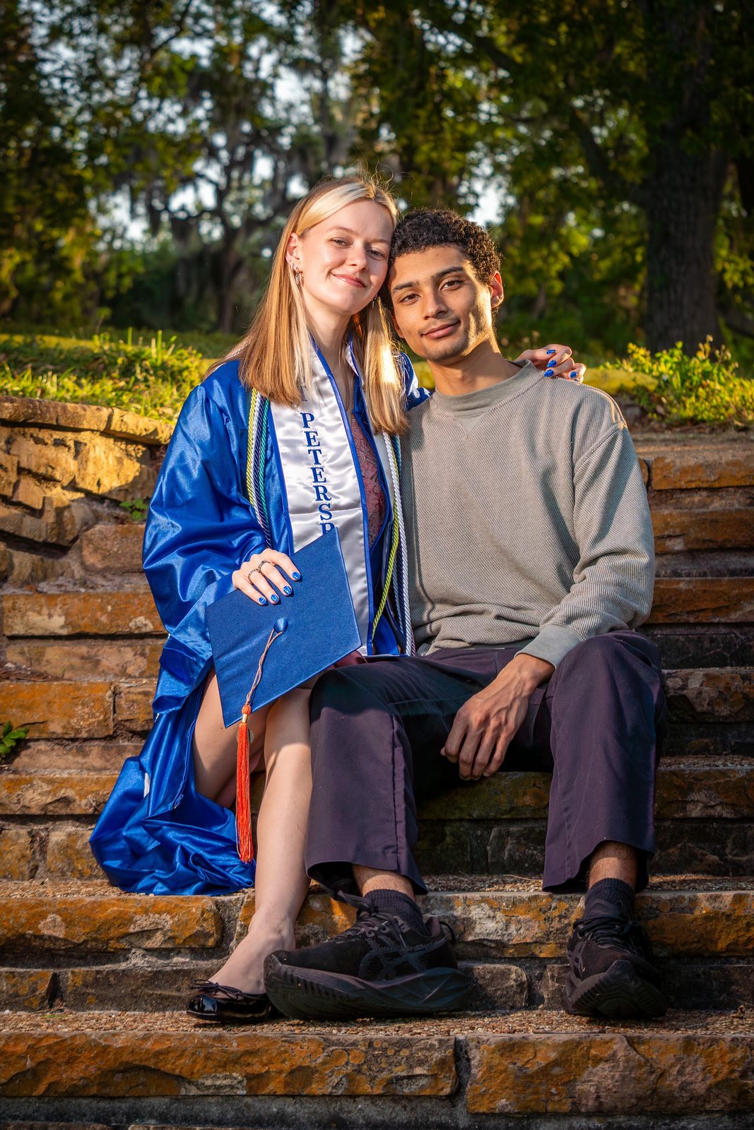 Graduation photo of two people on stone steps outdoors